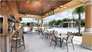 Un patio al aire libre con mobiliario y piscina.