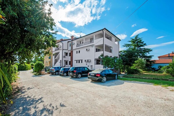 A multi-story residential building with a parking area in front. - Apartments San Francesco (Rovinj)