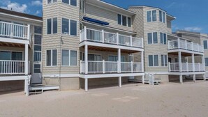 Un hôtel situé en bord de mer, doté de nombreux balcons, d’un espace extérieur couvert et d’une plage de sable.