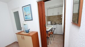 A compact kitchen with white cabinets, a microwave, and a sink. - Studio Sea (Rovinj)