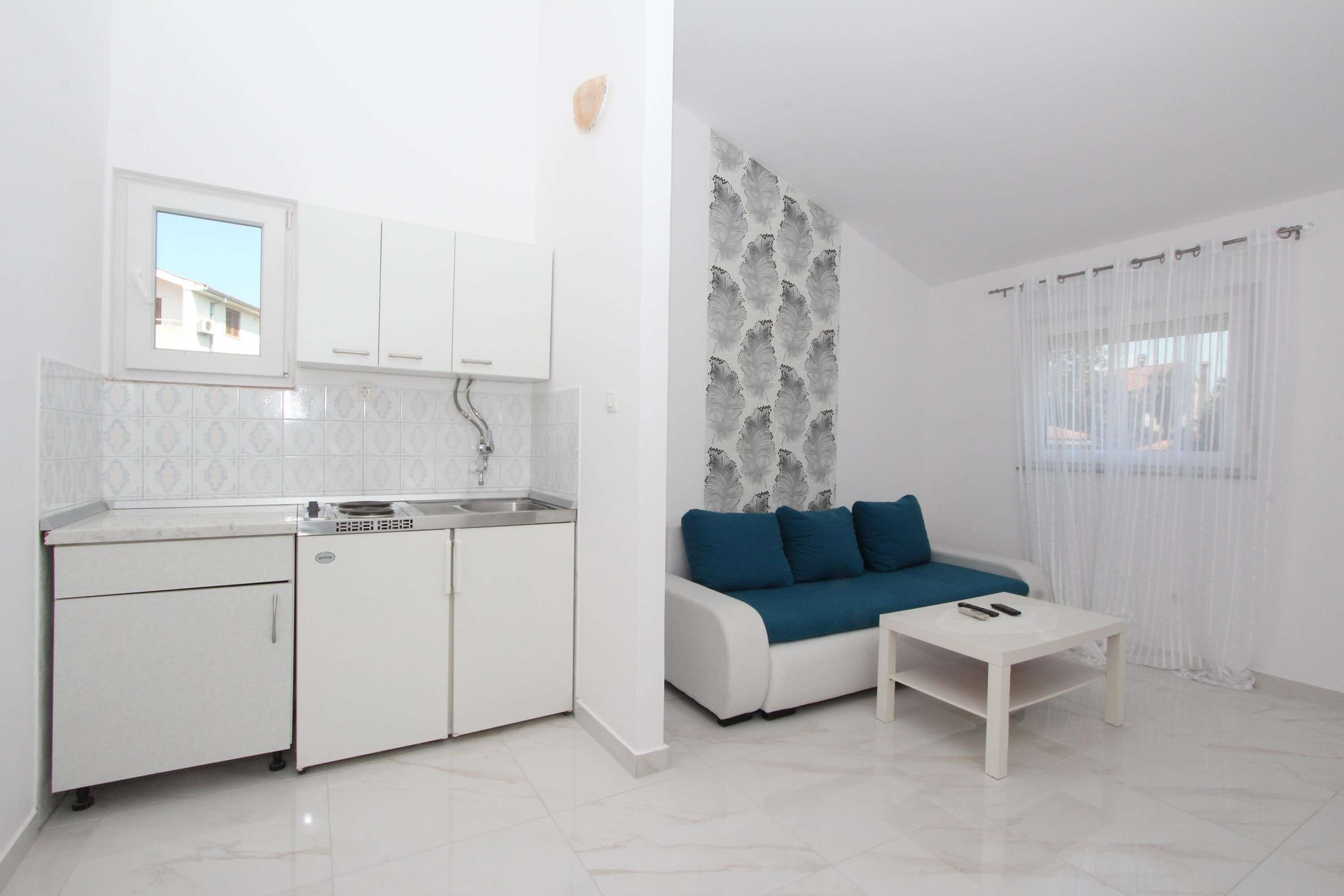 A compact living space with a kitchenette, a sofa, and a coffee table.