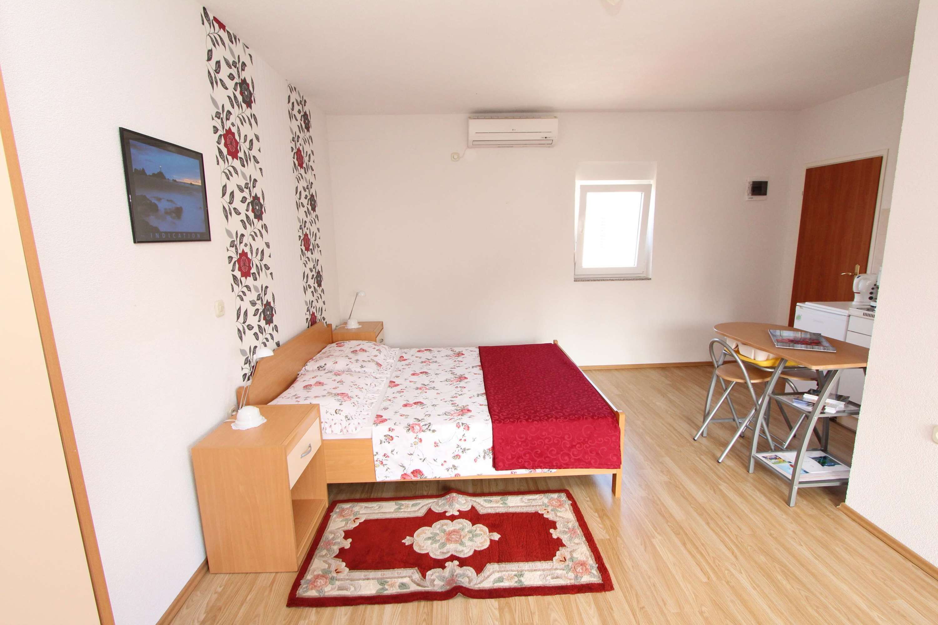 Una camera da letto con un letto, un comodino e una scrivania con una sedia.