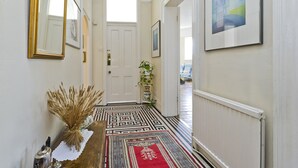 A hallway with a patterned rug, a door, and a radiator.