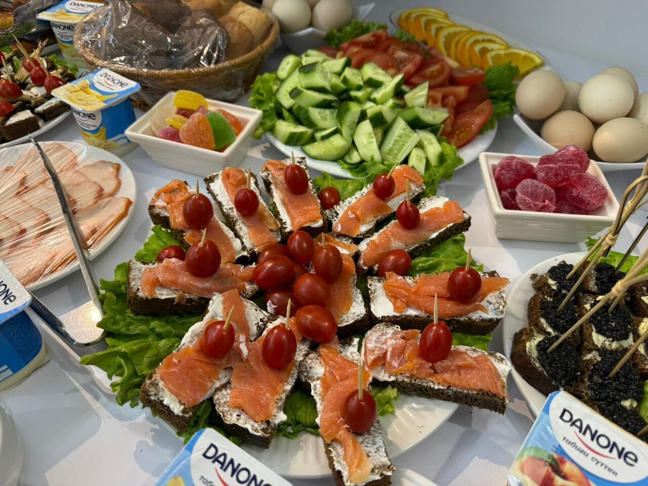 Un buffet proposant une variété de plats, notamment du saumon fumé, des tomates cerises et d’autres amuse-gueules.
