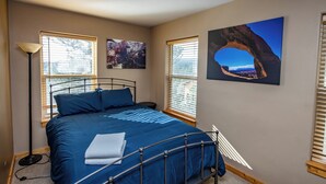 A bedroom with a bed, two windows, a floor lamp, and two wall art pieces. - Hot Tub! Close to Fishing, ATV, Hiking, Rafting, Rivers! (Pagosa Springs)