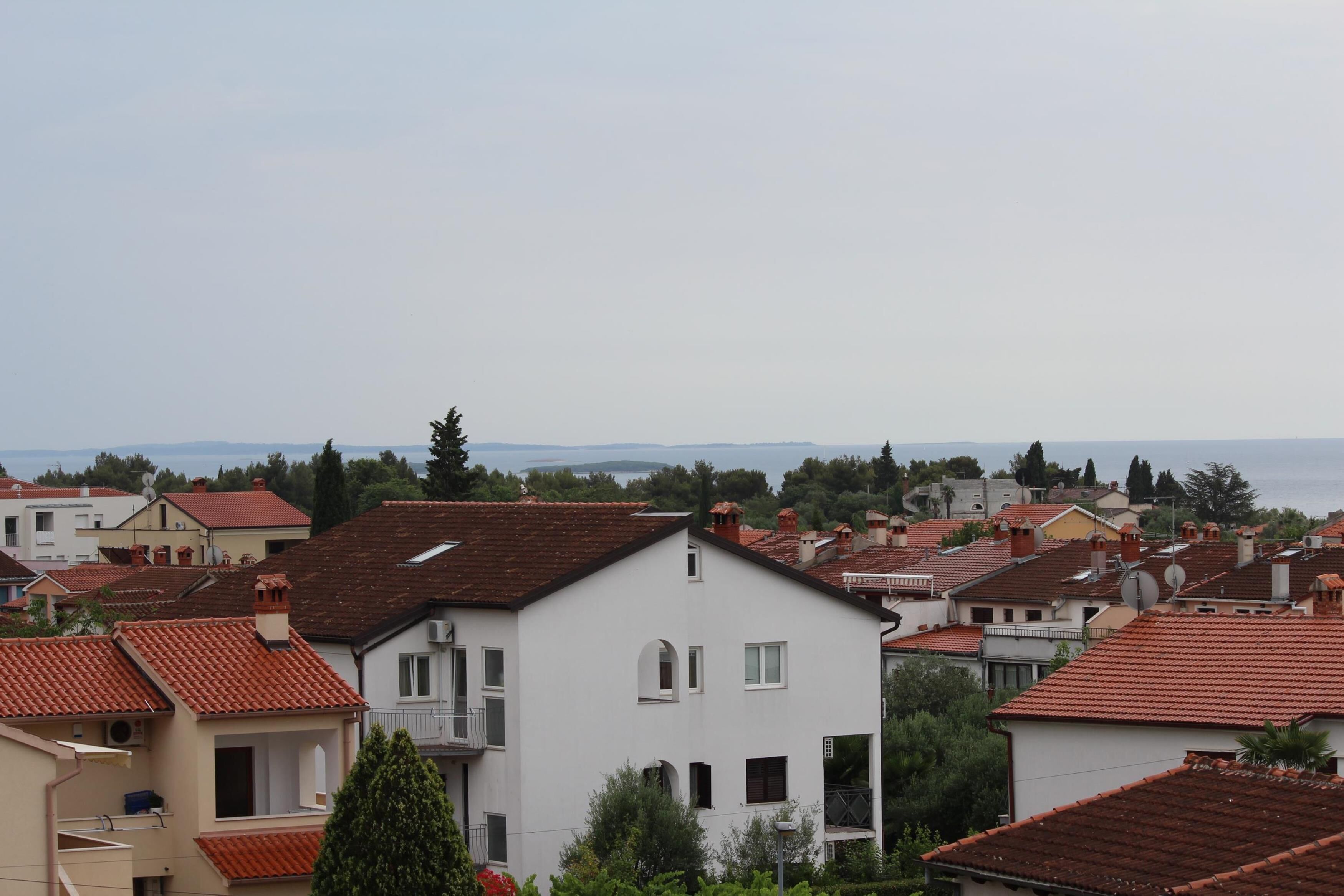 A residential area with multiple houses featuring red-tiled roofs and white walls.