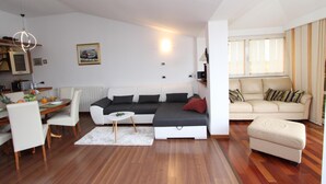 Een moderne woonkamer met een bank, een eettafel en een salontafel.