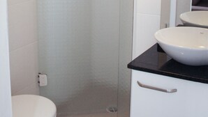 Ein Badezimmer mit Toilette, Waschbecken und einer Duschkabine.