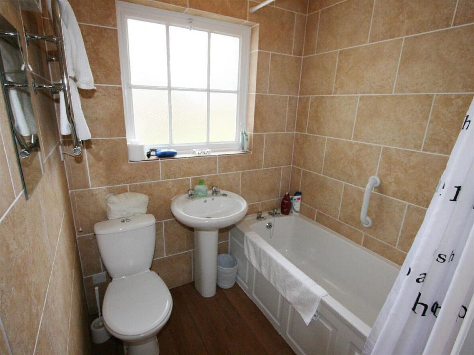 Een badkamer met toilet, wastafel en bad.