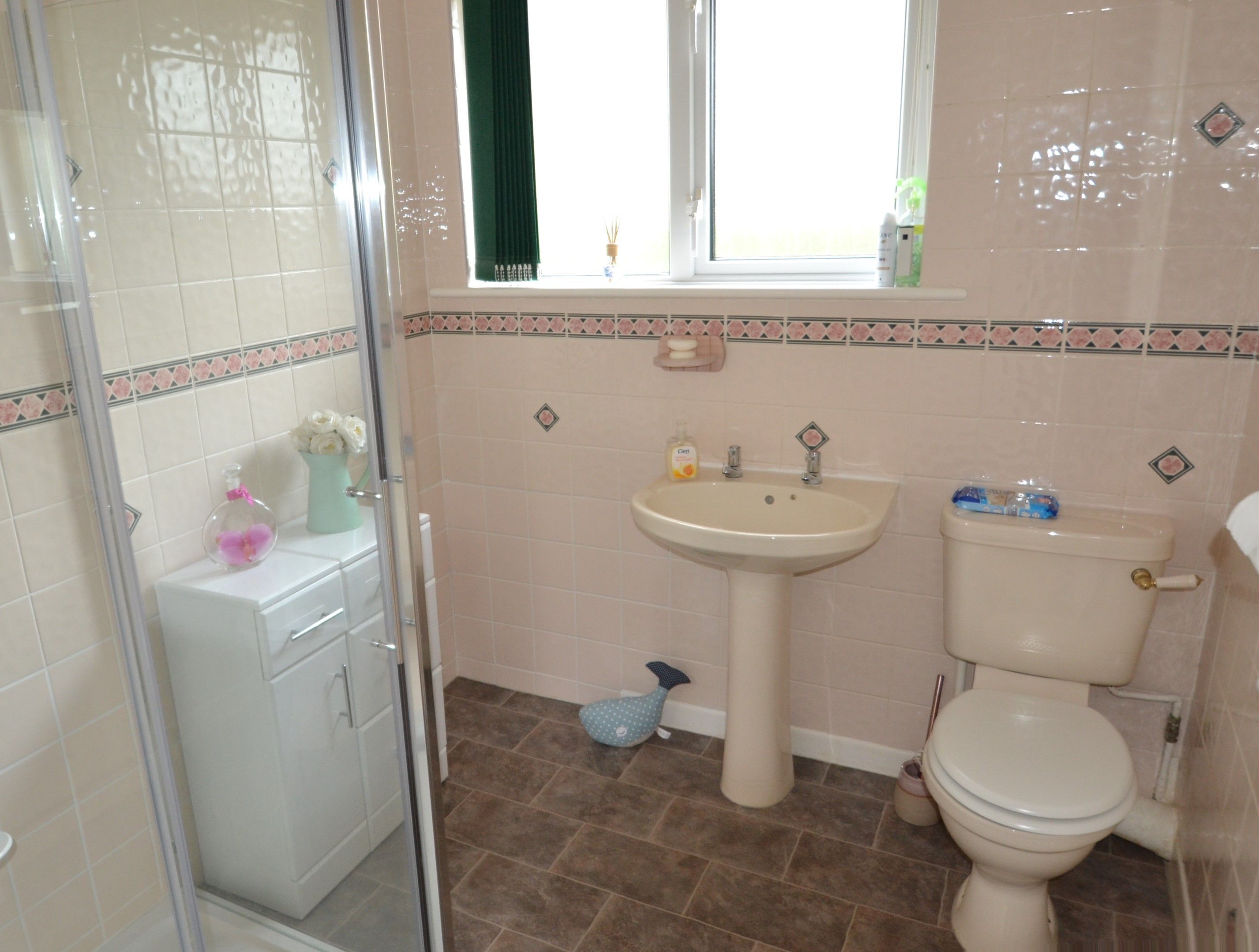 Une salle de bain comprenant un lavabo, des toilettes et un espace douche.