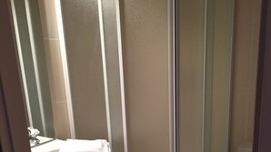 A bathroom with a glass shower enclosure, a white sink, and a toilet. - Le Grand Joly (Sainte-Agnès)