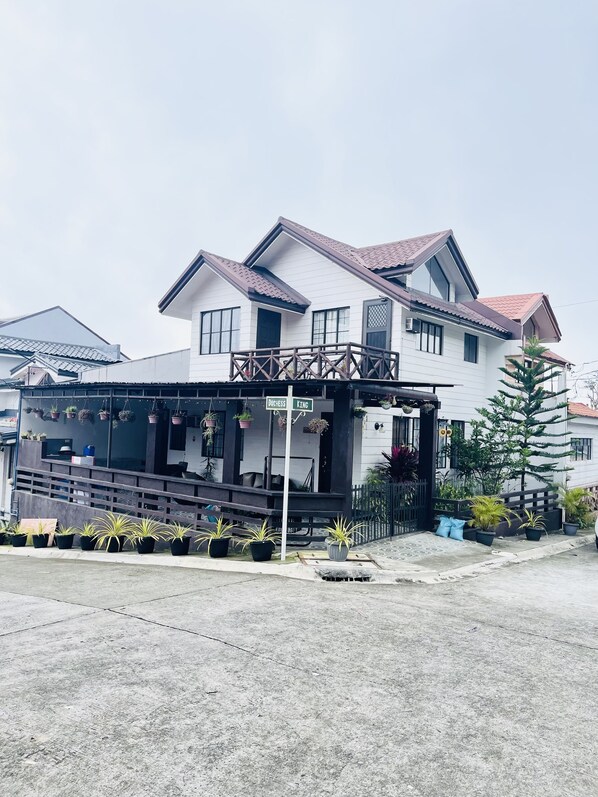 A two-story house with a balcony, potted plants, and a sign indicating "Duchess King." - D’Waldz Villa Tagaytay  (Alfonso)