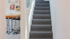 A staircase with patterned carpet leading to a landing. - Windsor House - A Home from home (Derry)