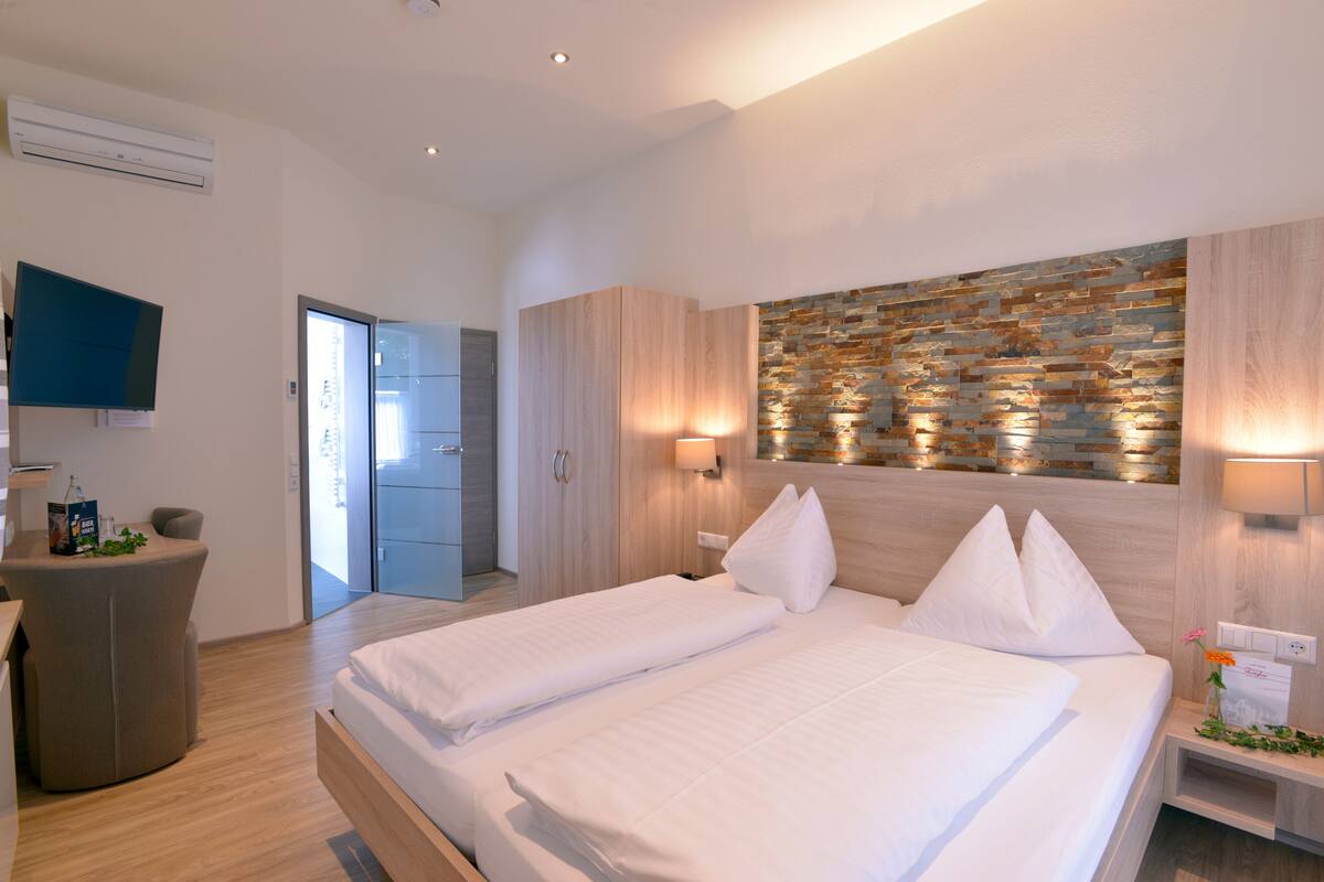 Une chambre d’hôtel moderne avec un grand lit, un bureau et une télévision.