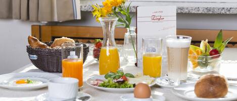 Una mesa de desayuno con diversas opciones, como huevos, tostadas y fruta.