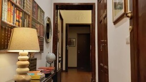 Un pasillo con una lámpara, estanterías y una puerta.