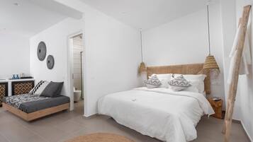 Une chambre à coucher moderne avec un grand lit, un petit canapé et une tête de lit en bois.