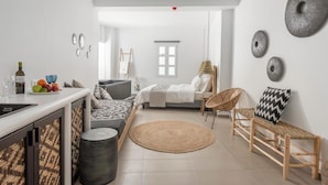 Een moderne, open woonruimte met keuken, eethoek en slaapkamer.