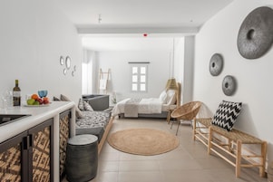 A modern, open-plan living space with a kitchen, dining area, and a bedroom.