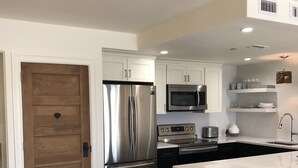 A modern kitchen with white cabinetry, stainless steel appliances, and a marble countertop. - Beachfront Condo, 1 King Bedroom + Bunk, 2 baths, sleeps 5 (Destin)