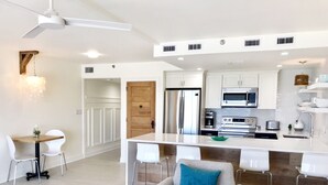 A modern kitchen with white cabinetry, stainless steel appliances, and a central island. - Beachfront Condo, 1 King Bedroom + Bunk, 2 baths, sleeps 5 (Destin)