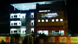 A multi-story hotel with illuminated signage reading "HOTEL DEL RIO HUMADEA SELAH WANERO". - Hotel Rio Humadea (Guamal)