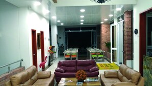 A spacious lobby with leather sofas, a coffee table, and a chandelier. - Hotel Rio Humadea (Guamal)