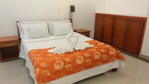 A hotel room with a bed, a nightstand, a telephone, and wooden wardrobe. - Hotel Rio Humadea (Guamal)