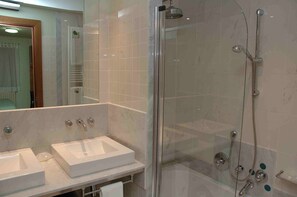 A modern bathroom with two sinks, a glass shower enclosure, and a mirror. - Hotel Vall Fosca (La Torre de Cabdella)