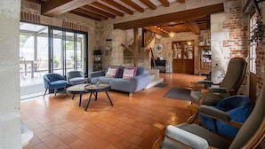 A spacious living room with a fireplace, a staircase, and a view of the outdoors. - Le Prieure des Fontaines (Les Preaux)