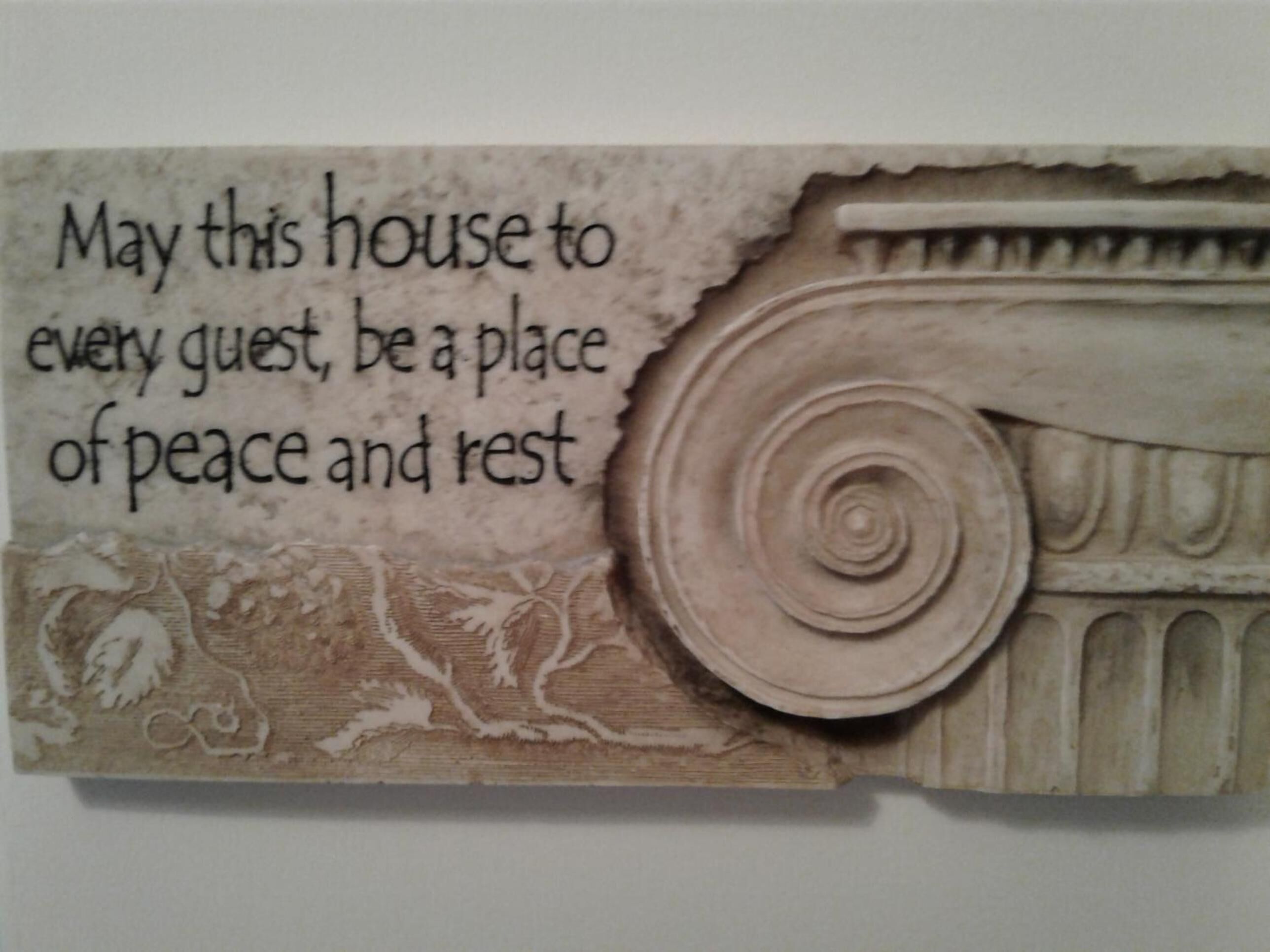 A decorative piece with a quote about peace and rest, and a classical column design.