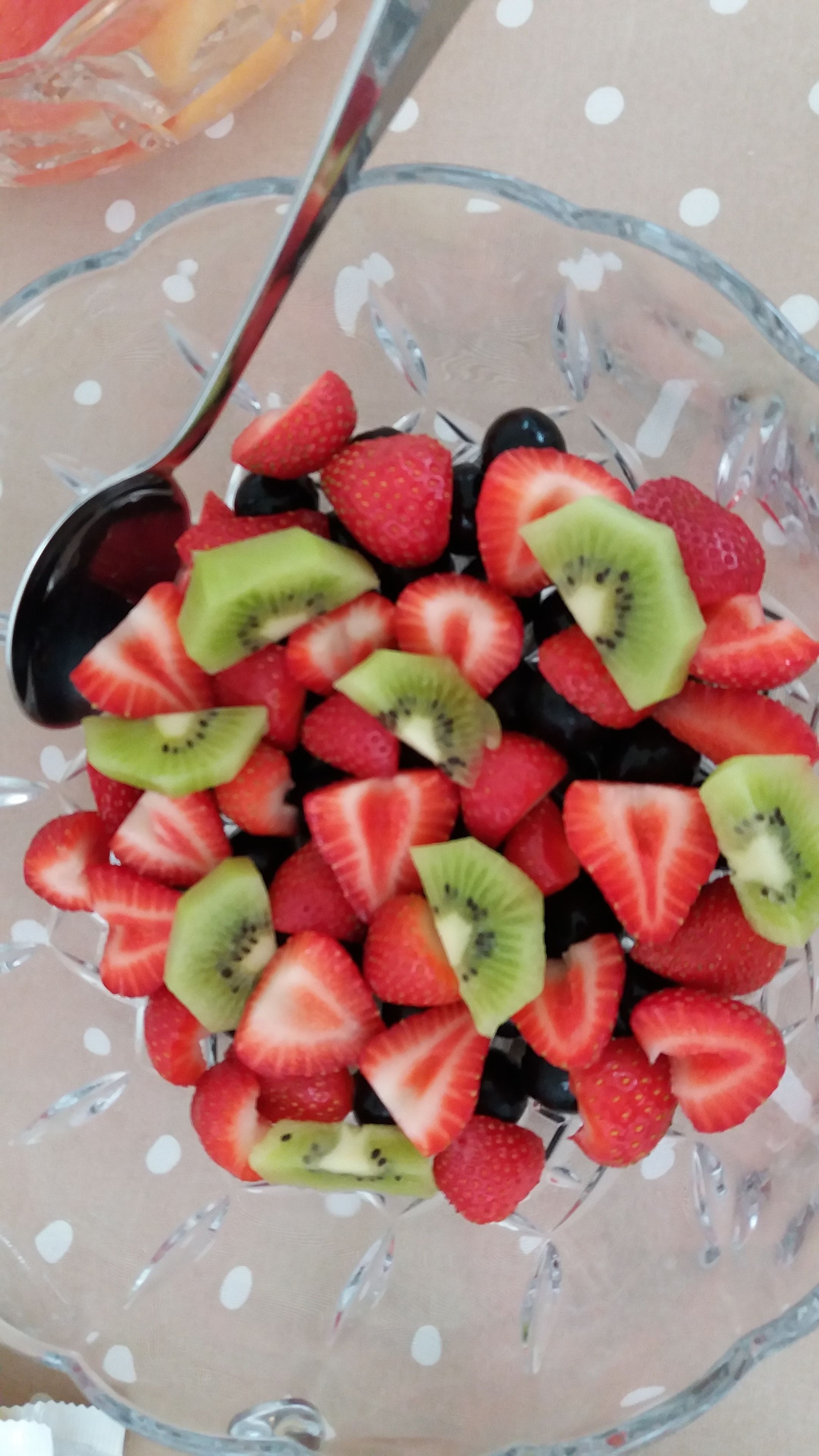 Eine Glaskugel mit geschnittenen Erdbeeren und Kiwis.