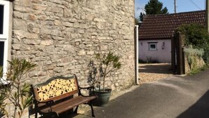 A stone building with a bench and potted plants. - Hathway House (Bristol)