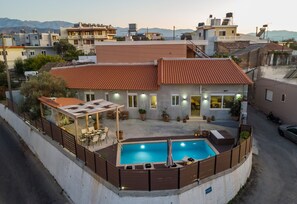 Ein Wohnhaus mit Swimmingpool, Sitzgelegenheiten im Freien und Blick auf die umliegende Nachbarschaft.