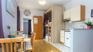 Une cuisine de taille réduite, dotée de meubles en bois, d’une cuisinière encastrée et d’un évier.