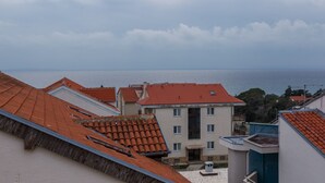 A coastal building with red-tiled roofs and a view of the sea. - Apartment with Terrace and Partial Sea View and grill (Novalja)