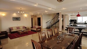 Amplia sala de estar con comedor, una escalera y una cocina.