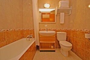 Een bad, handdoeken, toiletpapier