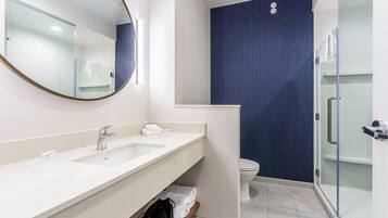 Une salle de bain moderne avec deux lavabos, des toilettes et une douche à l’italienne.