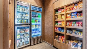 Zona de venta automática con múltiples estantes llenos de diversas botanas y bebidas.