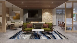 Una sala de estar moderna con chimenea, asientos cómodos y un tapete grande.