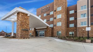 A Fairfield Inn & Suites by Marriott hotel with a stone facade, large entrance, and a covered walkway.