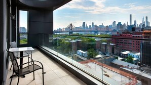 A balcony with a city view, a table, and two chairs. - TownePlace Suites by Marriott New York Long Island City/Manhattan View (Long Island City)