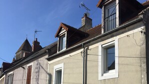 A row of townhouses with stone foundations, white walls, and brown shutters. - La Maison de la Grève (Ouistreham)
