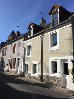 A row of townhouses with stone foundations, white walls, and brown shutters. - La Maison de la Grève (Ouistreham)