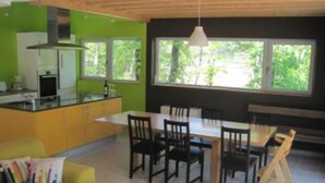 A modern kitchen with a dining area. - Modern wooden house with tree terrace and private heated pool (Luzech)