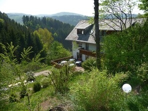 A house with a balcony overlooking a forested valley. - Landhaus Valentin (Triberg im Schwarzwald)