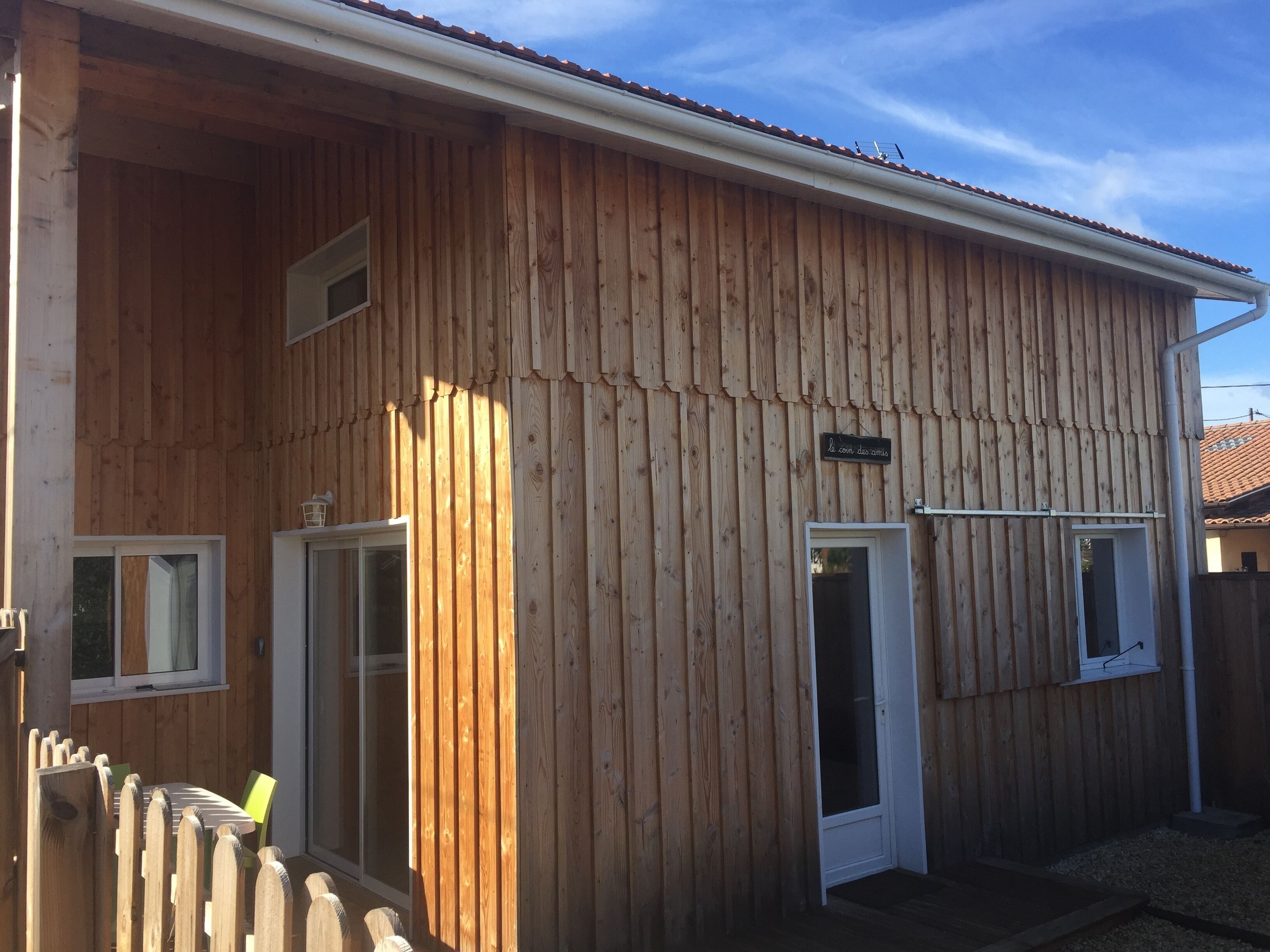 A wooden building with a corrugated exterior, two doors, and a small window.