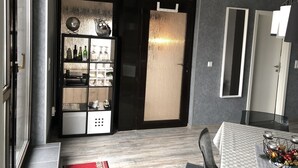 A modern dining area with a glass partition, a wooden cabinet with glassware, and a checkered tablecloth. - Beautiful apartment with large sun terrace - Apartment Elegance (Höheischweiler)