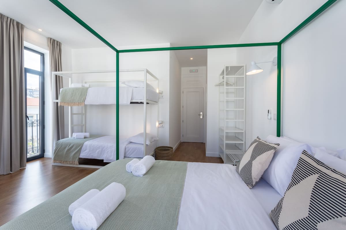 A hotel room with a bunk bed, a single bed, and a walk-in closet.